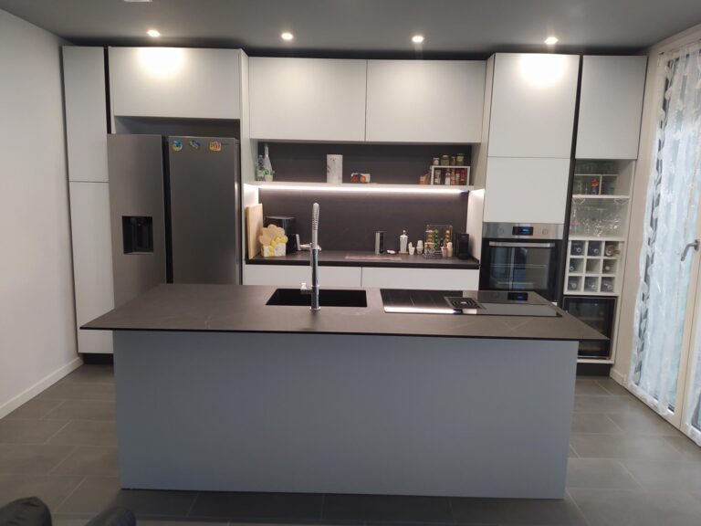 Cucina con isola grigia e colonne bianche con cantinetta
