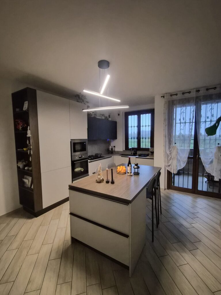 Cucina ad angolo con isola e illuminazione a soffitto